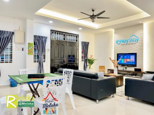uma sala de estar com um sofá e uma mesa em GardenHomeStay TownArea Karaok Mahjong PrivatePool By HeystayManagement em Malaca
