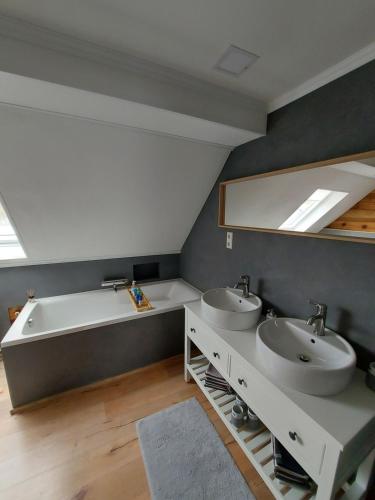 a bathroom with two sinks and a bath tub at Ferienhaus am Bornfeld in Leimen