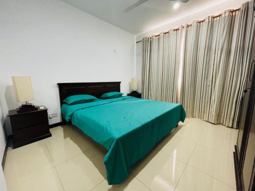 a bedroom with a bed with a blue comforter at Great Escape in Colombo