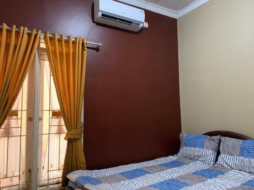 Schlafzimmer mit einem Bett und einem Fenster in der Unterkunft Simple Home near Baturraden in Rempawah