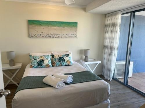 a bedroom with a large bed and a window at Centrepoint Apartments Caloundra in Caloundra