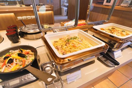 a buffet filled with different types of food on a counter at Higashikawa Asahidake Onsen Hotel Bear Monte in Higashikawa