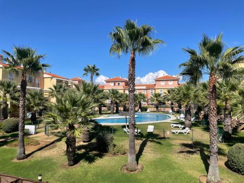 una vista aérea de un complejo con palmeras y piscina en Lovely family house by the golf course, en Huelva