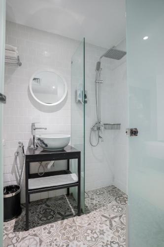 a bathroom with a sink and a glass shower at Floresta Hotel Chinatown in Kuala Lumpur