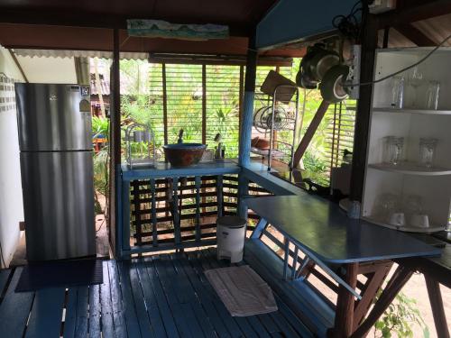 a kitchen with a table and a refrigerator on a deck at Bangpo Village Tiny Country Beach House in Koh Samui 