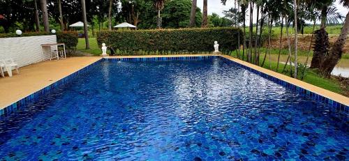 a swimming pool with blue water in a yard at Uthai River Lake Resort in Ban Nong Nam Khan