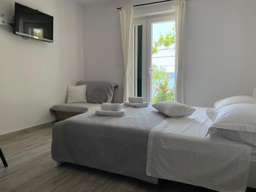 biała sypialnia z łóżkiem i oknem w obiekcie Apartments Tom w Mimicach