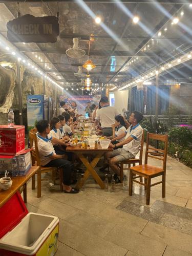 grupa ludzi siedzących przy stole jedzących jedzenie w obiekcie Chay Moutain Valley Bugalow w mieście Ninh Binh