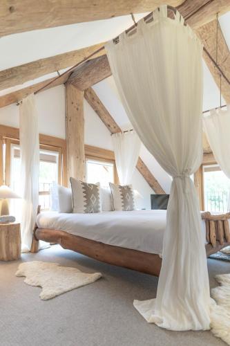 a bedroom with a large bed with curtains at Wild Nurture Eco Luxury Offgrid Log Cabin in Fort William