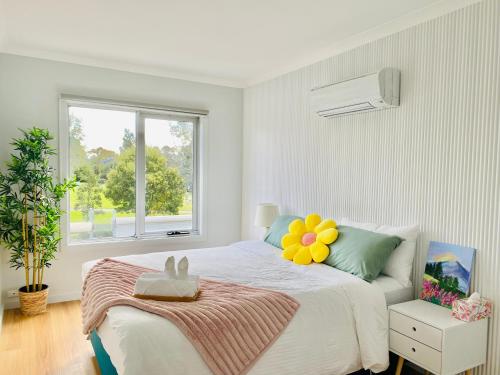 1 dormitorio con cama con almohada de flores en The Daisy House - Family-friendly & top convenient location, en Melbourne