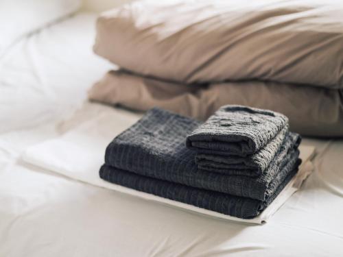 a pile of towels on a plate on a bed at guesthouse SHIBAFU in Kamakura