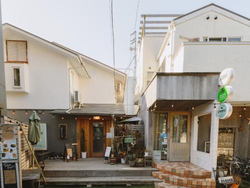 un magasin à l'avant d'un bâtiment blanc avec une terrasse couverte dans l'établissement guesthouse SHIBAFU, à Kamakura