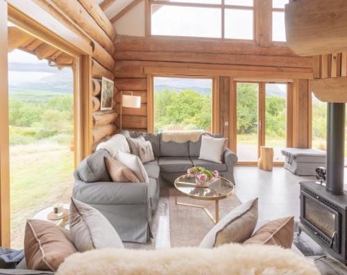 a living room with a couch and a fireplace at Wild Nurture Eco Luxury Offgrid Log Cabin in Fort William