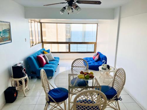 a living room with a blue couch and a table and chairs at Casa de la Playa in Macuto