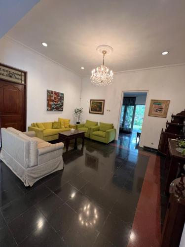 uma sala de estar com sofás e um lustre em SOETJIPTO HOME STAY VILLA em Jakarta