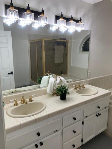 a bathroom with two sinks and a large mirror at Executive home in a serene park like setting in Folsom