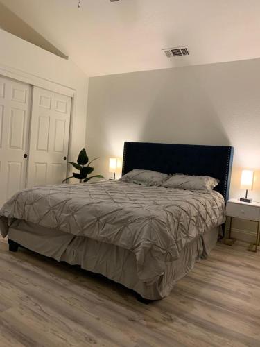 a bedroom with a bed with two lamps and two tables at Executive home in a serene park like setting in Folsom