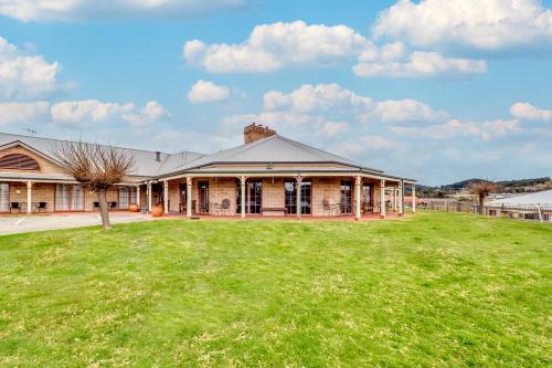 ein Haus mit einem großen Garten davor in der Unterkunft Bowen Inn Motel in Lithgow