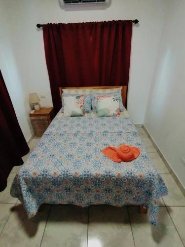 a bedroom with a bed with a red curtain at Casa Paraiso Tropical in Parrita