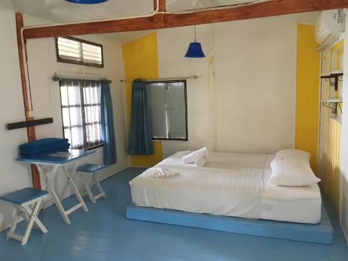 a bedroom with a bed and a table and a desk at Bangpo Village Tiny Country Beach House in Ban Bang Po