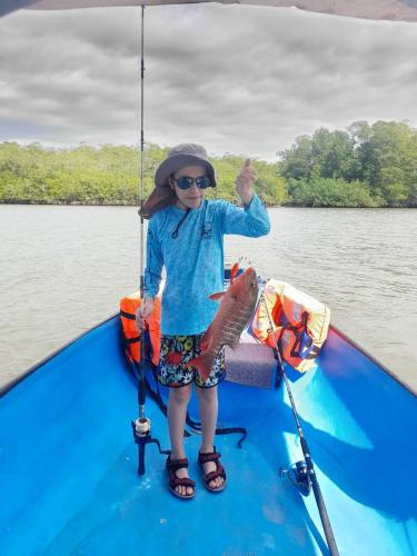 a young girl holding a fish on a boat at Casa Paraiso Tropical in Parrita