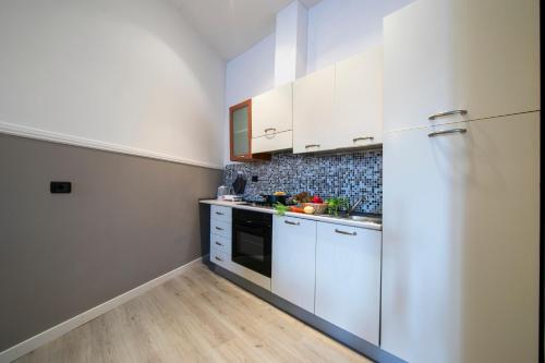 a kitchen with white cabinets and a refrigerator at Menaggio Tosca Apartments in Menaggio