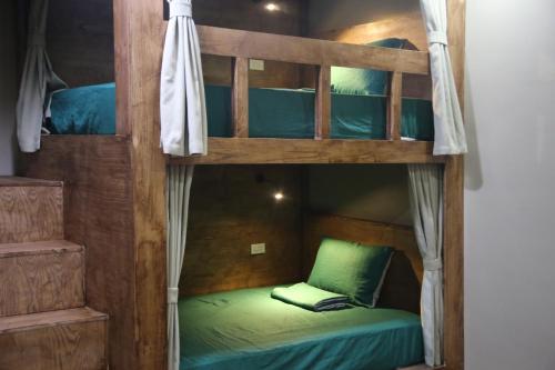a bunk bed with a green bed in a room at The Banana Tree Hostel in Ninh Binh