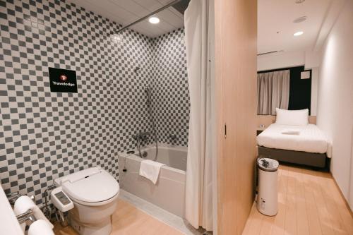 a bathroom with a toilet and a sink and a tub at Travelodge Honmachi Osaka in Osaka