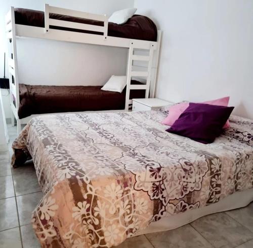 1 dormitorio con 1 cama y 1 litera en Departamento Nina en Caleta Olivia