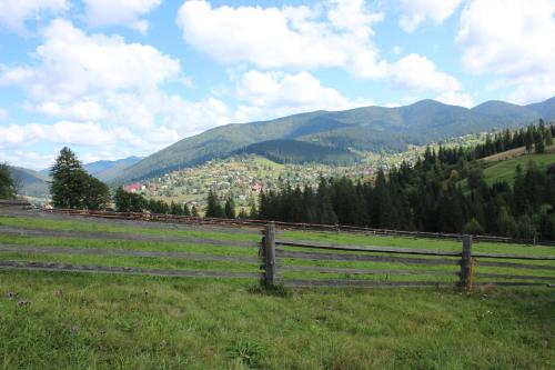 a wooden fence in a field with mountains in the background at Мелодія Гір .Апартаменти з видом на гори . in Vorokhta
