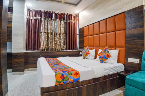 FabHotel Brij Residency في Naiāpura: غرفة نوم بسرير وكرسي ازرق