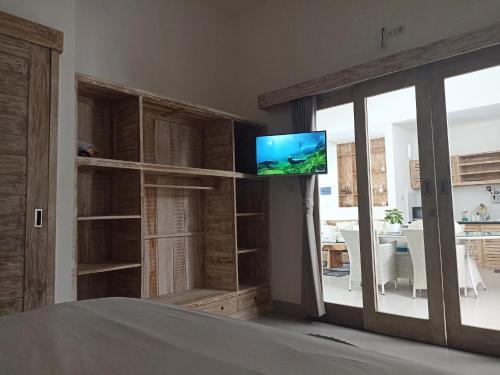 a living room with a tv on a wall at Villa Of Course x Kerobokan x Canggu x Seminyak in Kerobokan