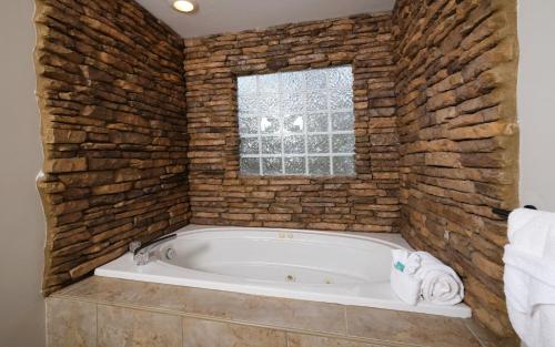 a bath tub in a room with a brick wall at Shady Creek in Gatlinburg