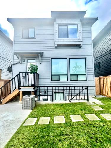 a house with a balcony and a yard at Stylish, Glamorous & Serene 6BR Villa, Near Vancouver, Oasis for Groups and Large Families in Langley