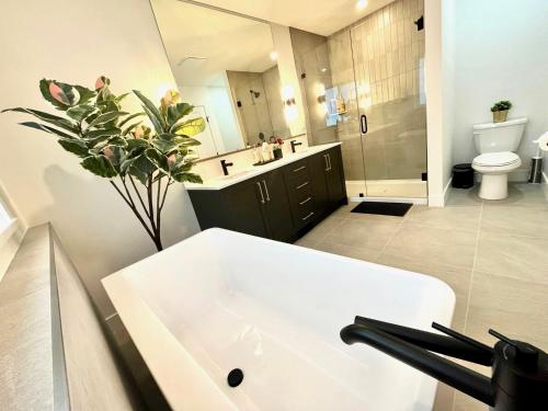 a bathroom with a white sink and a toilet at Stylish, Glamorous & Serene 6BR Villa, Near Vancouver, Oasis for Groups and Large Families in Langley