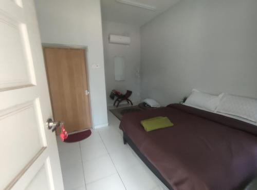 1 dormitorio con 1 cama con manta marrón y puerta en Cahaya roomstay en Kangar