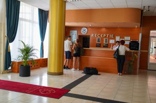 Complex Balnear Covasna في كوفزنا: مجموعة من الناس واقفين في بهو الفندق