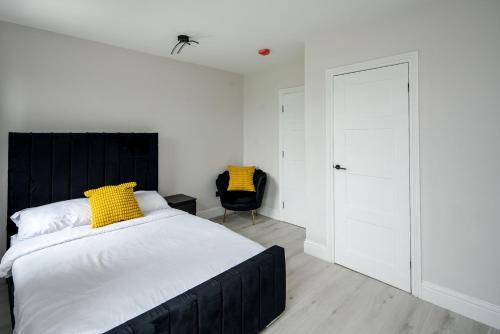 a bedroom with a bed with a yellow pillow on it at CommonSide Luxury in Mitcham