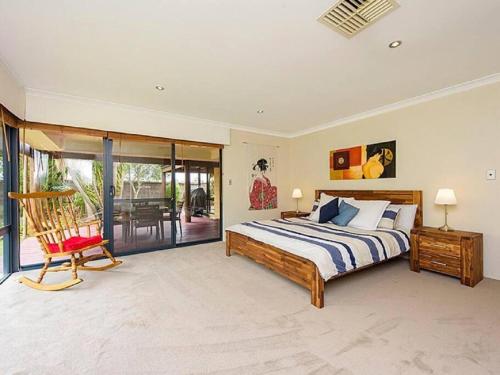 a large bedroom with a bed and a chair at Sky Blue Retreat in North Boyanup