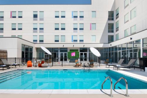 a swimming pool in front of a building at Aloft Oklahoma City Quail Springs in Oklahoma City