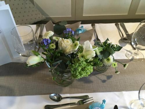 a vase filled with white and blue flowers on a table at Hotel-Gasthof Weisses Ross in Schwaig bei Nürnberg