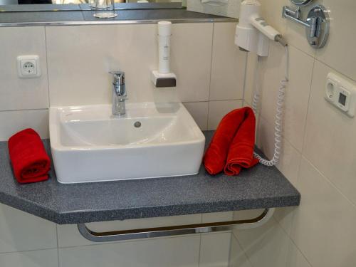 a bathroom counter with a sink and a phone at Hotel-Gasthof Weisses Ross in Schwaig bei Nürnberg