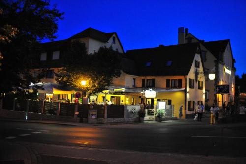 a building on the side of a street at night at Hotel-Gasthof Weisses Ross in Schwaig bei Nürnberg