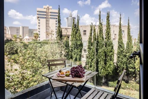 un plato de fruta en una mesa en un balcón en Old Charm & Modern Meets in Haifa by Sea N' Rent, en Haifa