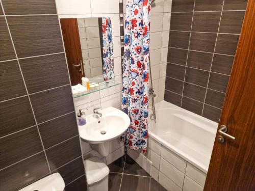une salle de bain avec un lavabo, des toilettes et une baignoire dans l'établissement Sunny Apartment C25, à Borovets