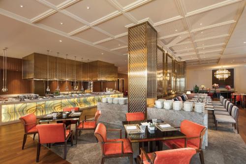 a restaurant with tables and chairs and a bar at Hilton Dalian Golden Pebble Beach Resort in Jinzhou