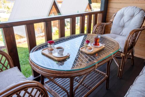 una mesa y sillas en un balcón con mesa y bebidas en Aronia Bungalow, en Elmalık