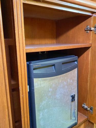 a small blue refrigerator in a wooden cabinet at Hotel Sandakan in Sandakan