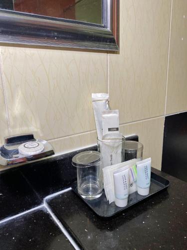 a tray with cups sitting on a kitchen sink at Hotel Sandakan in Sandakan