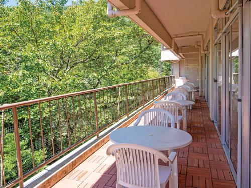 a row of tables and chairs on a balcony with trees at 真田昌幸-幸村父子の隠れ宿 紀伊見荘 in Hashimoto
